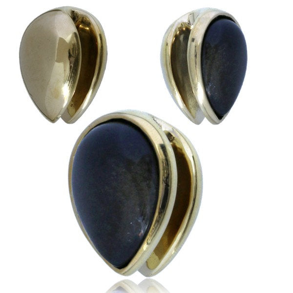 A pair of OBI Minimalist Oval Ear Hangers from Kaya Movement. Each ear hanger features a teardrop-shaped black stone encased in a shiny golden obsidian setting. The gold wraps partially around the stone, creating a sleek and elegant design.